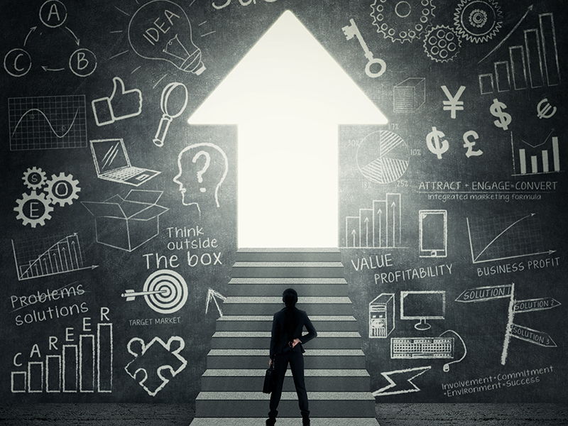 Businesswoman standing on the stairs and looking at bright door