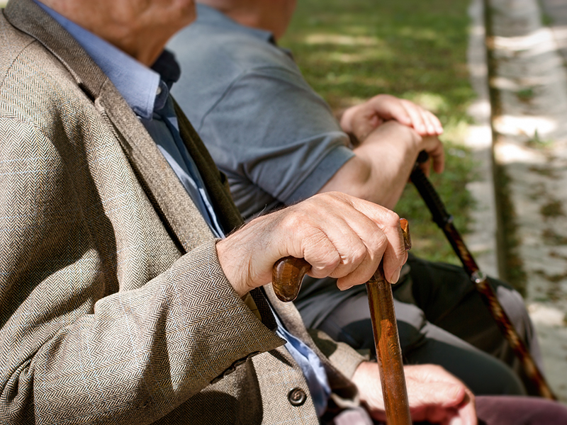 Pensioners, friends sitting in the park and resting - concept of a retirement age