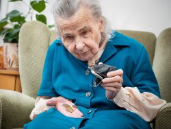 elderly caucasian woman counting coins in her hands