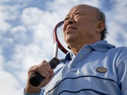 A shot of a senior asian man holding a tennis racquet