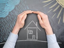 A young businesswoman protects a house from the elements - rain or storm and sun. Blackboard drawing, top view.