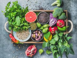 Healthy food ingredients in wooden box over grey background