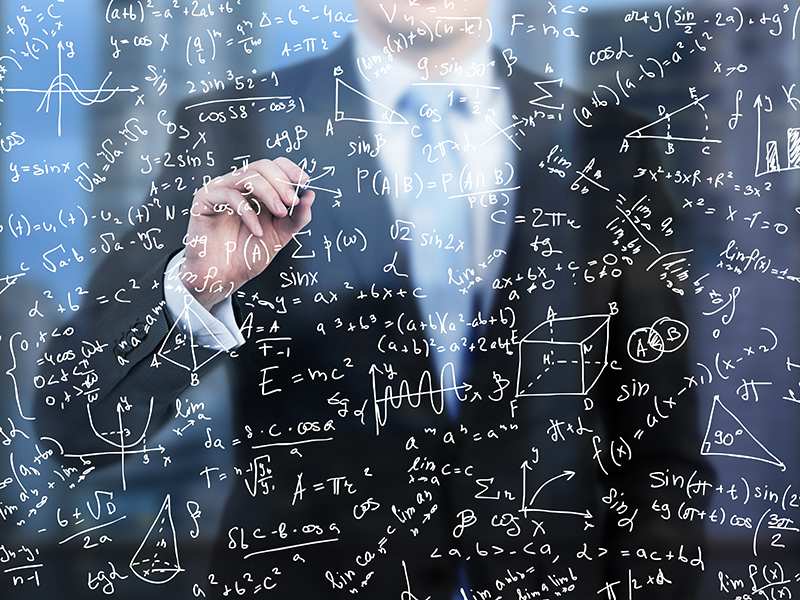 A business person is writing down math formulas on the glass screen in the evening modern panoramic office.