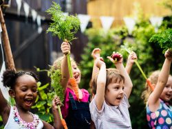 Kids in a vegetable garden with carrot