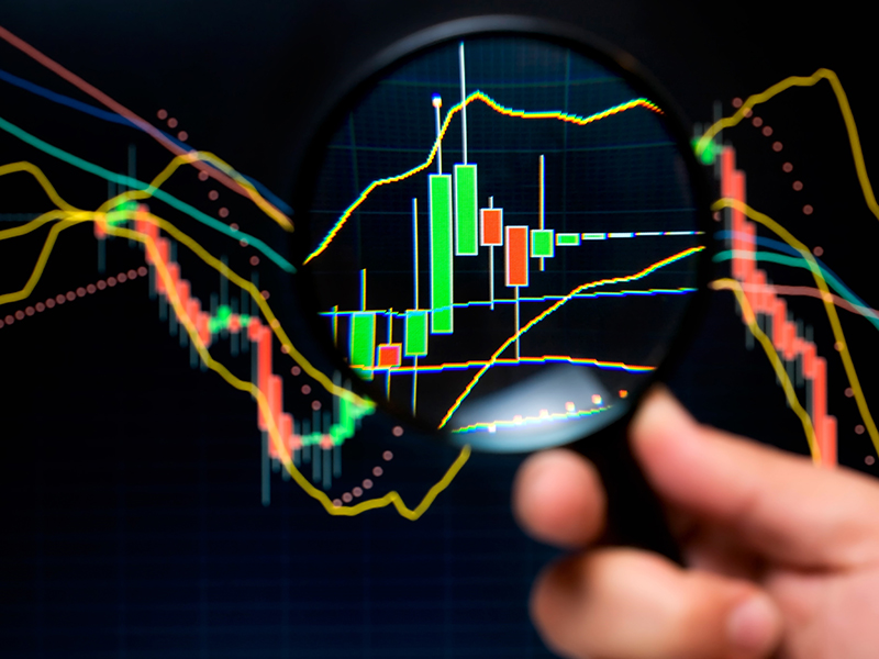 magnifier and graph, basic tools of technical analysis on the stock market.