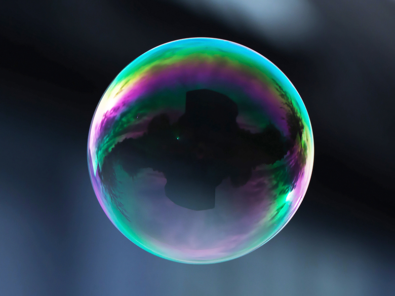 A flying soap bubble with reflection of a building.