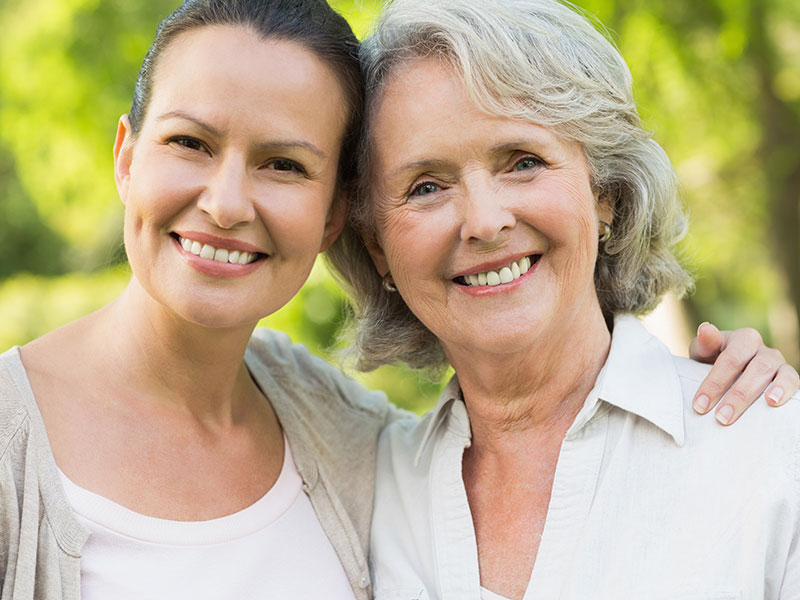 Close-up of smiling mature woman with daughter at park