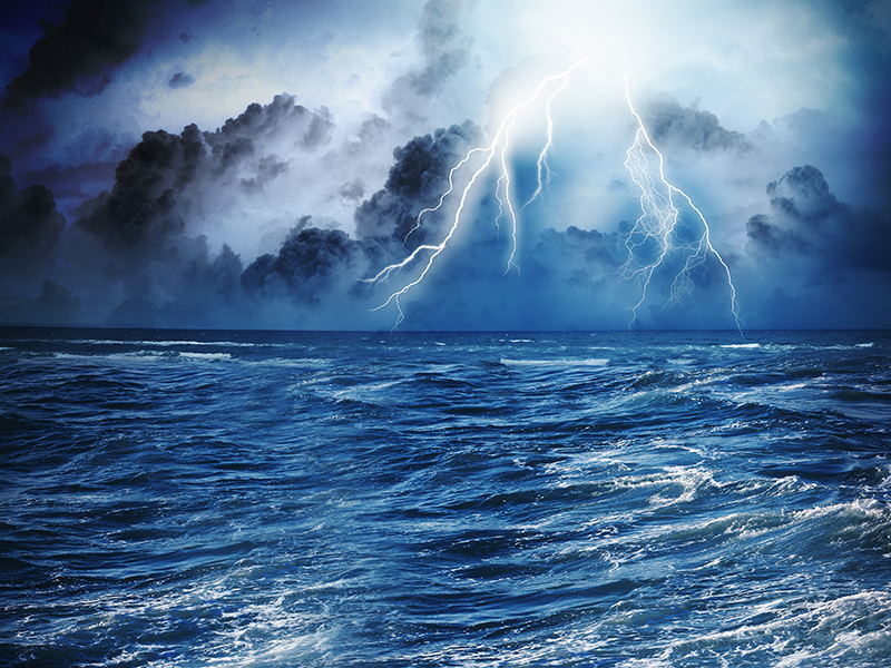 Image of dark night with lightning above stormy sea