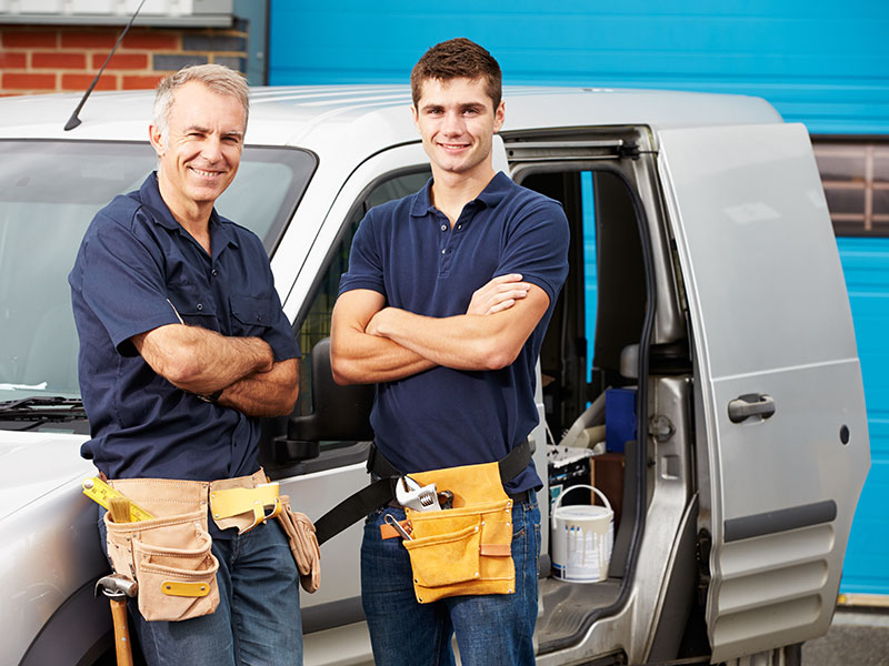 Workers In Family Business Standing Next To Van