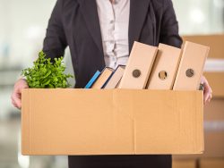 Close-up. Smiling young businesswoman holding cardboard box with her things.