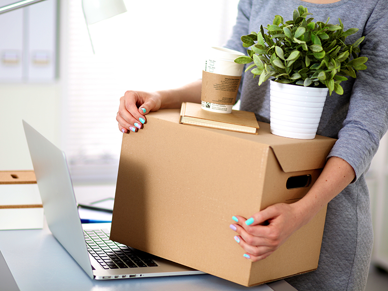 Happy team of businesspeople moving office, packing boxes, smiling.