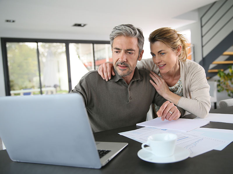 Couple calculating financial savings on internet