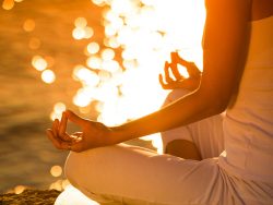 Woman in a yoga position on a beautiful beach