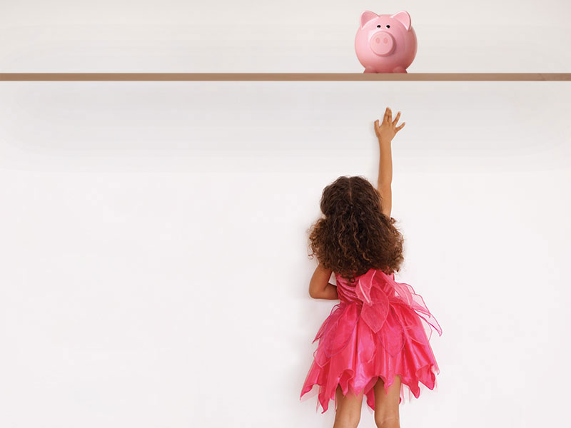Girl reaching for a piggy bank out of reach