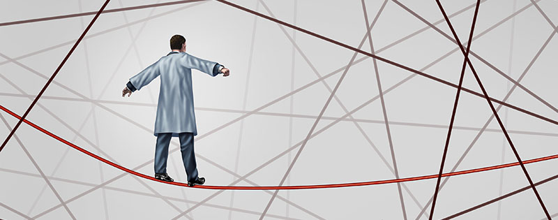 Medical solution health care concept as a doctor walking on a red tightrope or highwire around a group of tangled wires as a symbol of challenges in insurance and the risk in illness treatment for patients.