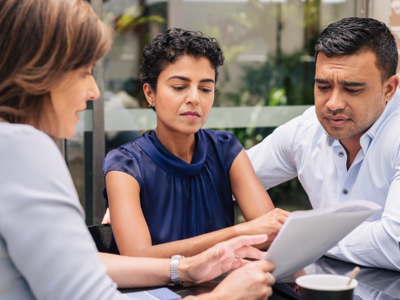 Serious looking couple, ages 40-55, receives financial advice.