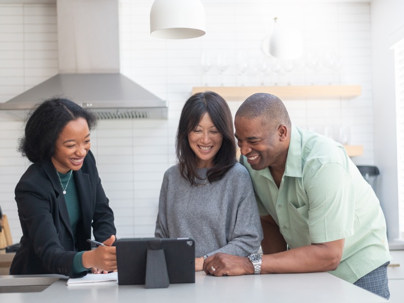 Financial advisor meeting with happy and affectionate couple in their home.