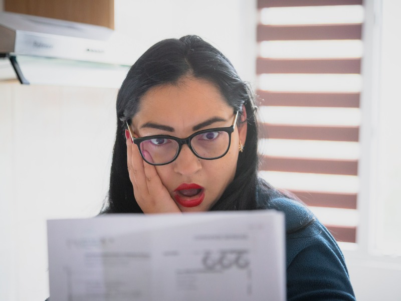 Worried woman checking bills at home stock photo