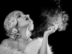 luxury young woman smoking on black background, monochrome